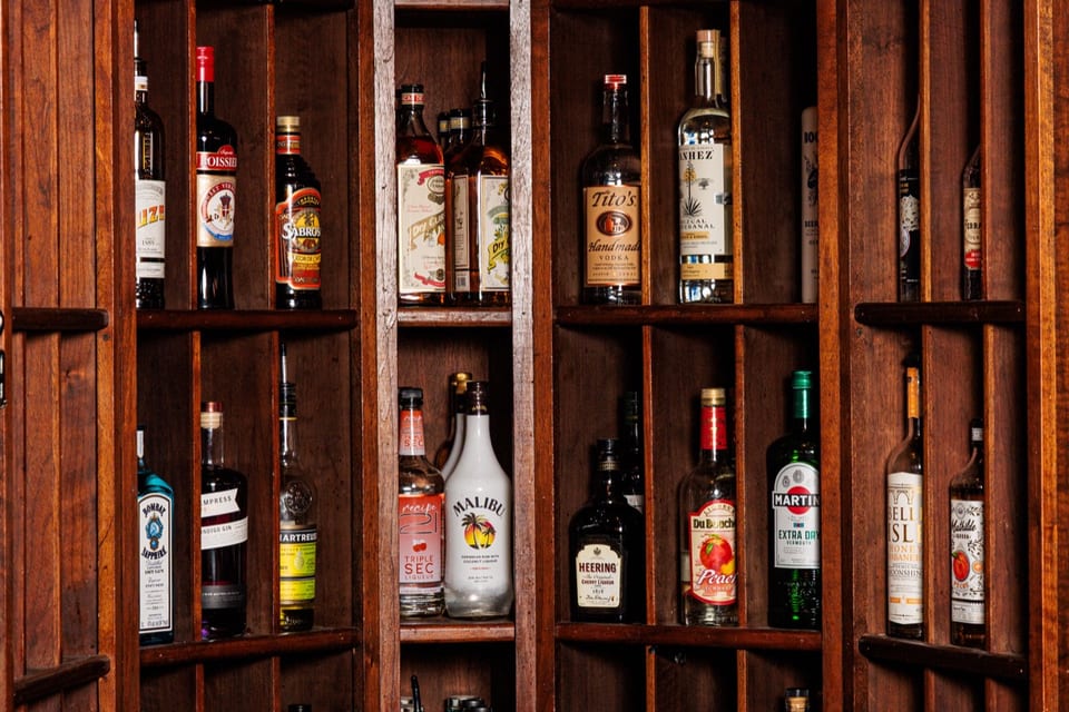 A quiet row of wine bottles in soft light at The Alexander bar