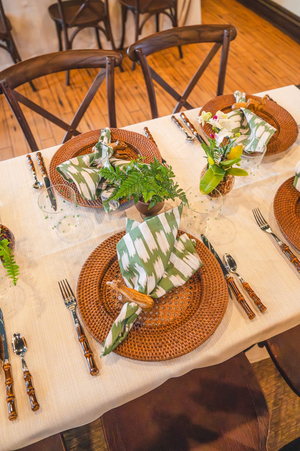 Top-down shot of a place setting with orchid centerpiece and woven charger