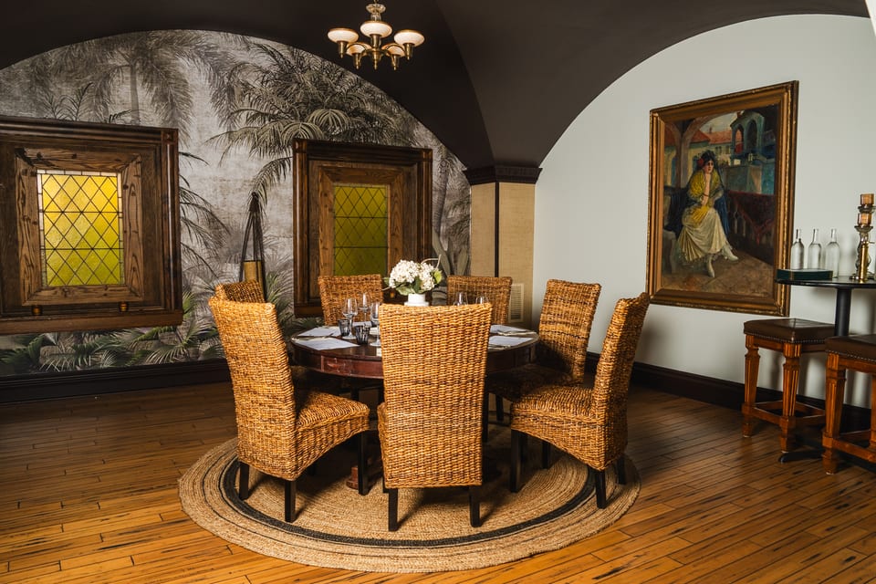 The Tonga Room with wicker chairs, tropical wallpaper, and stained glass