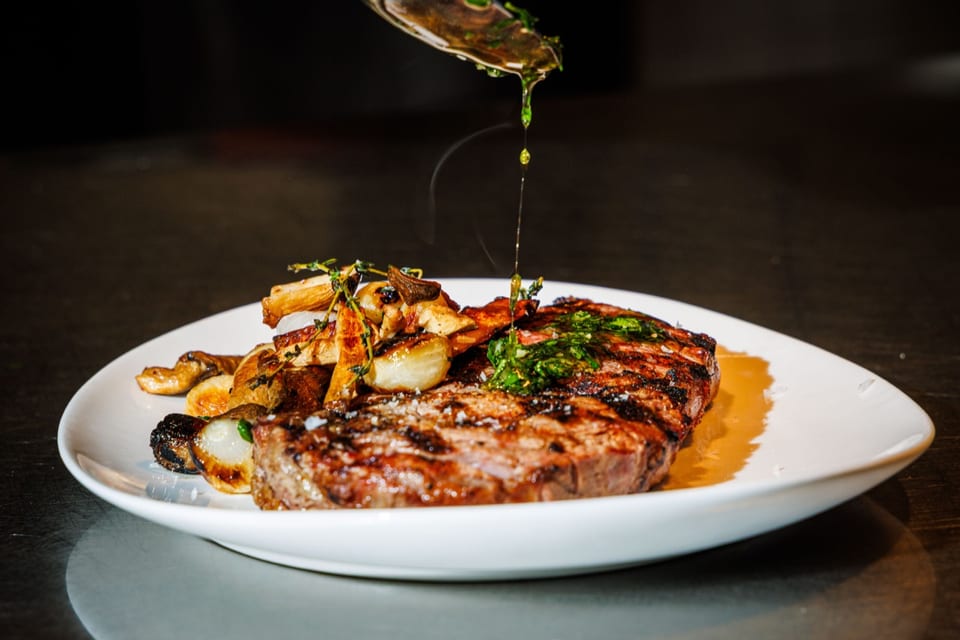 Chef plating steak in the kitchen — cooked to order