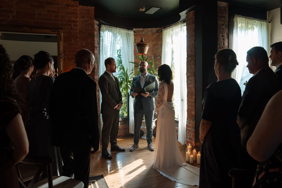 Wedding ceremony in the brick-arched turret with hanging candles and sheer curtains